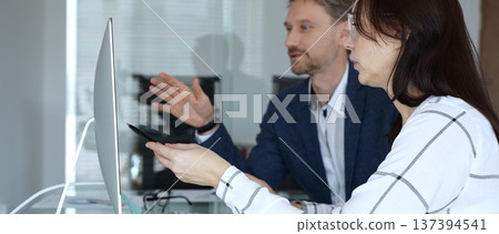 Business colleagues collaborating on data analysis, watching financial graphs and charts on computer monitor. Businesspeople concept Business colleagues collaborating on data analysis, watching financial graphs and charts on computer monitor. Businesspeople concept 137394541