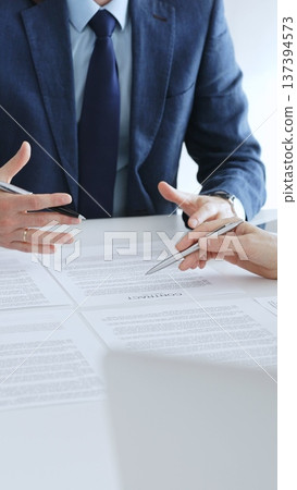 Businesspeople hands with pens reviewing documents and engaging in a discussion across a table, representing contract signing, legal consultation, negotiation, and important agreement collaboration Businesspeople hands with pens reviewing documents and engaging in a discussion across a table, representing contract signing, legal consultation, negotiation, and important agreement collaboration 137394573