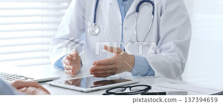 Female doctor explaining diagnosis to her patient during a medical consultation in a bright medical office, healthcare and medical concept. Medicine and health care concept 137394659