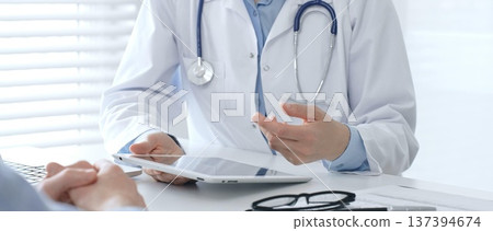 Female doctor explaining diagnosis to her patient during medical consultation in medical office, healthcare and medical concept. Medicine and healthcare concept 137394674