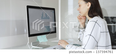 Woman analyst working on computer, analyzing business data with charts and graphs, marketing report on screen. Businesspeople concept Woman analyst working on computer, analyzing business data with charts and graphs, marketing report on screen. Businesspeople concept 137394761
