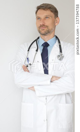 Portrait of a confident male doctor wearing stethoscope and white coat, standing with crossed arms and gazing thoughtfully, representing medical professionalism and expertise Portrait of a confident male doctor wearing stethoscope and white coat, standing with crossed arms and gazing thoughtfully, representing medical professionalism and expertise 137394788