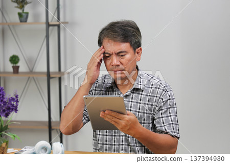 Asian senior man too serious at work. Asian senior man too serious at work. 137394980