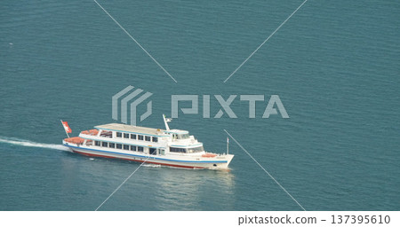 Boat moves across blue water near the shore during sunny day in a coastal area with clear sky Boat moves across blue water near the shore during sunny day in a coastal area with clear sky 137395610