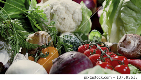 Fresh vegetables and herbs arranged on a table ready for cooking or preparation in a kitchen setting Fresh vegetables and herbs arranged on a table ready for cooking or preparation in a kitchen setting 137395615