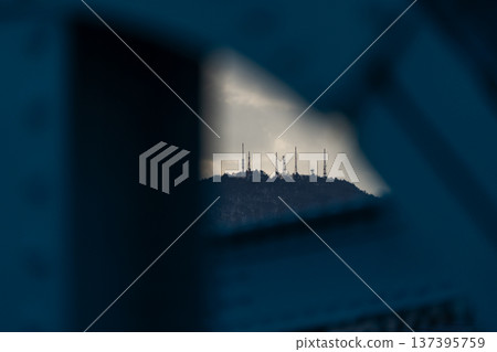 [Winter sky] A steel tower on the mountaintop, sunlight shining through the clouds, a steel bridge 137395759