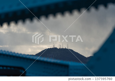 [Winter sky] A steel tower on the mountaintop, sunlight shining through the clouds, a steel bridge 137395760