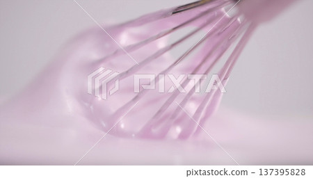 Whisk mixing pink batter in a bowl during a baking session in a kitchen at daytime Whisk mixing pink batter in a bowl during a baking session in a kitchen at daytime 137395828