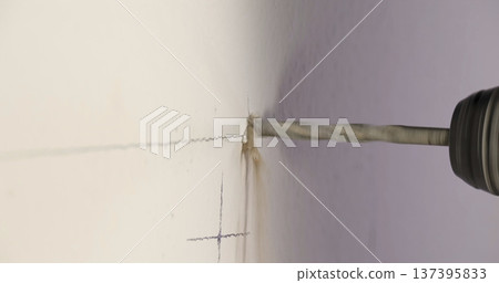 Drill creates hole in wall during home improvement project in a residential space, focusing on precise placement and clean work 137395833