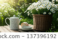 Teapot and plate with bread beside flower pot on wooden table outdoors 137396192