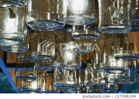 Vintage glass jars on the ceiling in the store in the evening. Light through the glass of the jar.    137396249