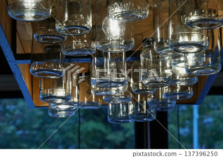 Vintage glass jars on the ceiling in the store in the evening. Light through the glass of the jar. Vintage glass jars on the ceiling in the store in the evening. Light through the glass of the jar. 137396250