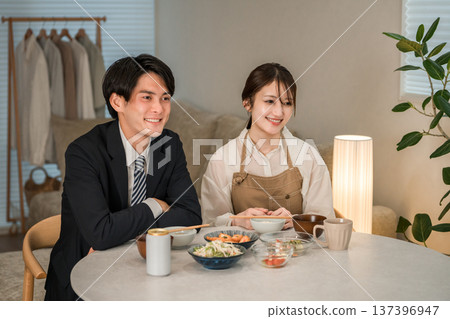 一對年輕的亞洲夫婦在家中餐桌上用餐。 137396947