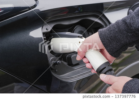 駕駛雙手連接電動車充電插頭 駕駛雙手連接電動車充電插頭 137397776
