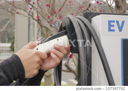 駕駛雙手連接電動車充電插頭 137397782