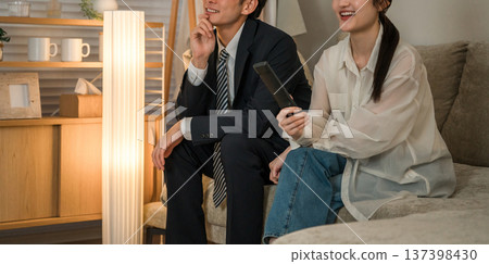A couple sitting on the sofa in the living room watching TV at night 137398430