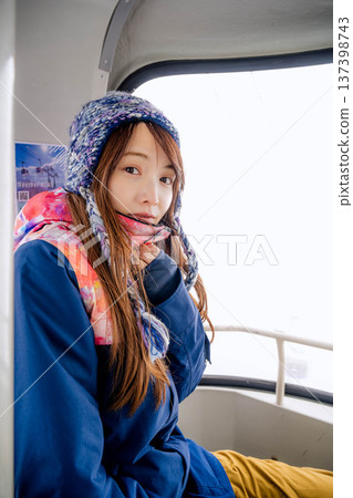 Young woman riding a gondola at a ski resort 137398743