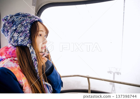 Young woman riding a gondola at a ski resort Young woman riding a gondola at a ski resort 137398744