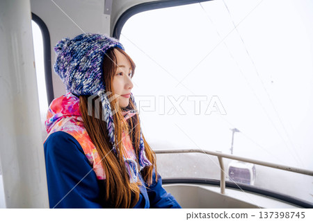 Young woman riding a gondola at a ski resort Young woman riding a gondola at a ski resort 137398745