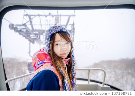 Young woman riding a gondola at a ski resort 137398751