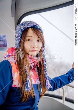 年輕女子乘坐滑雪度假村的纜車 年輕女子乘坐滑雪度假村的纜車 137398756