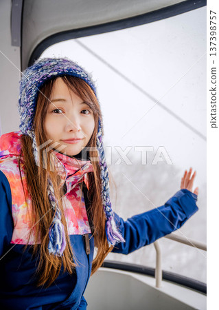 年輕女子乘坐滑雪度假村的纜車 年輕女子乘坐滑雪度假村的纜車 137398757