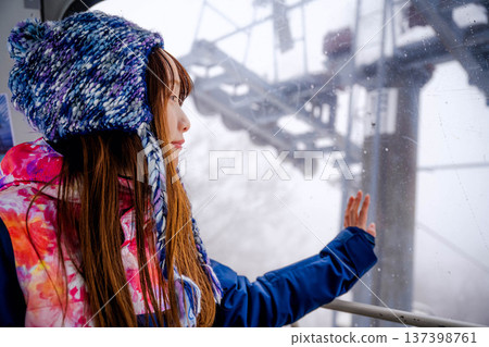 Young woman riding a gondola at a ski resort Young woman riding a gondola at a ski resort 137398761