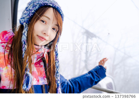 Young woman riding a gondola at a ski resort Young woman riding a gondola at a ski resort 137398766