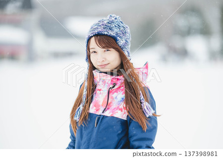 年輕女子在滑雪勝地的山坡上享受冬季運動－單板滑雪。 137398981