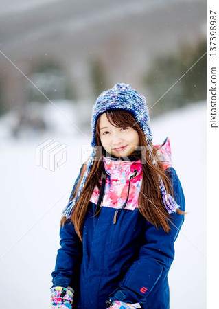 年輕女子在滑雪勝地的山坡上享受冬季運動-單板滑雪。 年輕女子在滑雪勝地的山坡上享受冬季運動-單板滑雪。 137398987