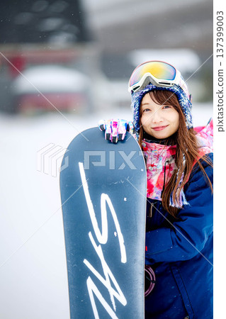 年輕女子在滑雪勝地的山坡上享受冬季運動-單板滑雪。 年輕女子在滑雪勝地的山坡上享受冬季運動-單板滑雪。 137399003