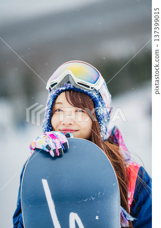 年輕女子在滑雪勝地的山坡上享受冬季運動－單板滑雪。 137399015