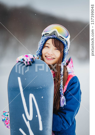 年輕女子在滑雪勝地的山坡上享受冬季運動－單板滑雪。 137399048