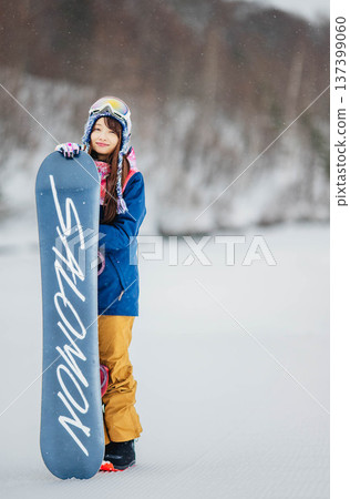 年輕女子在滑雪勝地的山坡上享受冬季運動－單板滑雪。 137399060