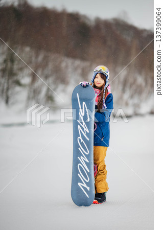 年輕女子在滑雪勝地的山坡上享受冬季運動－單板滑雪。 137399064