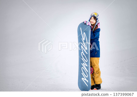 年輕女子在滑雪勝地的山坡上享受冬季運動－單板滑雪。 137399067