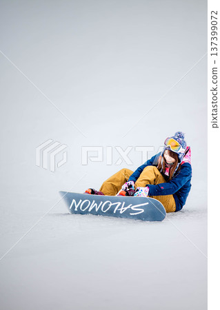 年輕女子在滑雪勝地的山坡上享受冬季運動－單板滑雪。 137399072