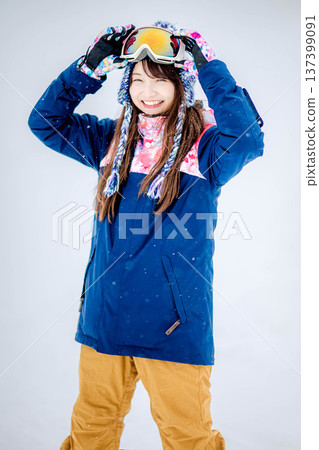 Young woman enjoying winter sports snowboarding on the slopes of a ski resort Young woman enjoying winter sports snowboarding on the slopes of a ski resort 137399091