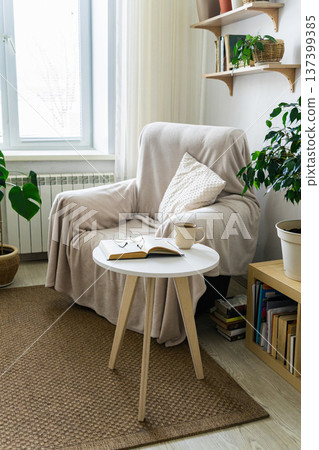 Cozy reading nook with armchair, plants, and natural light in minimalist interior Cozy reading nook with armchair, plants, and natural light in minimalist interior 137399385