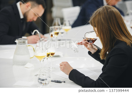 Female sommelier examination to get certificate professional work of winemaking. Sommelier degustate wine. 137399444
