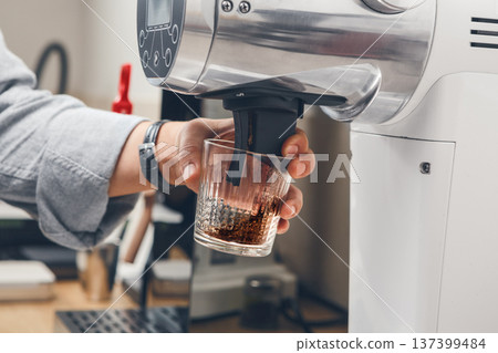 High-Quality Coffee Grinding in an Electric Professional Machine at a Coffee Shop High-Quality Coffee Grinding in an Electric Professional Machine at a Coffee Shop 137399484