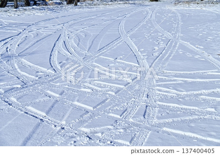 Tire patterns on a snowy parking lot 137400405