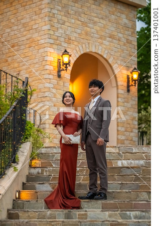 一對盛裝打扮的新人，身穿彩色禮服，在婚禮場地舉行夜間婚禮。 137401001