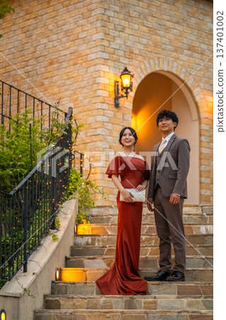 一對盛裝打扮的新人，身穿彩色禮服，在婚禮場地舉行夜間婚禮。 137401002