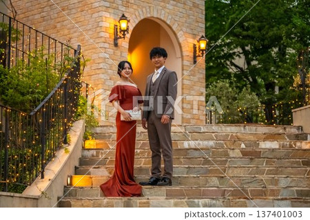 一對盛裝打扮的新人，身穿彩色禮服，在婚禮場地舉行夜間婚禮。 137401003