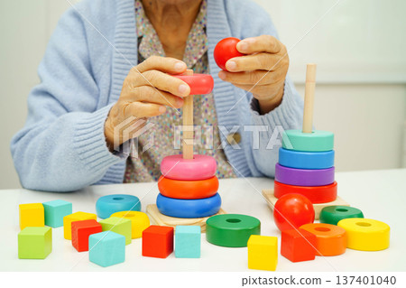 Asian elderly woman playing enhancing skill board game. Asian elderly woman playing enhancing skill board game. 137401040