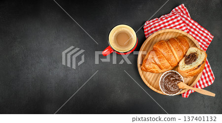Croissant Breakfast with Coffee and Chocolate Spread on Dark Background 137401132