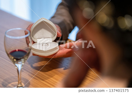 A man in a suit and tuxedo opening a jewelry case and ring case to show off a ring (marriage proposal) A man in a suit and tuxedo opening a jewelry case and ring case to show off a ring (marriage proposal) 137401575