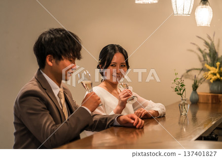 A couple in a dress code having a conversation while drinking champagne at a restaurant or bar A couple in a dress code having a conversation while drinking champagne at a restaurant or bar 137401827