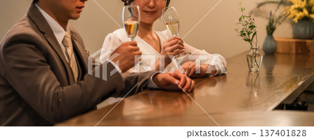 A couple in a dress code having a conversation while drinking champagne at a restaurant or bar A couple in a dress code having a conversation while drinking champagne at a restaurant or bar 137401828